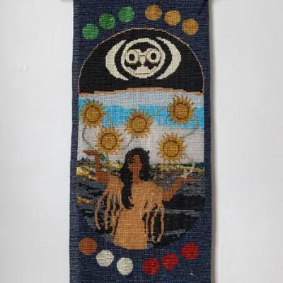 Beaded tapestry of a women and five suns hanging on a white wall